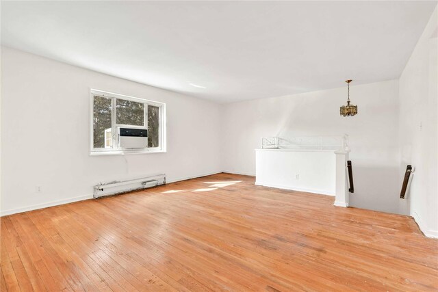 22401 Hillside Ave Unit 2, Queens Village, NY 11427 - unfurnished living room with baseboard heating, light wood-style floors, cooling unit, and a chandelier