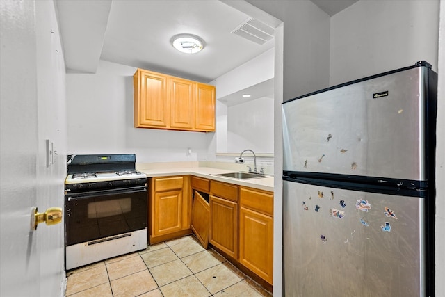 718 Garden St, Bronx, NY 10457 - kitchen with freestanding refrigerator, gas stove, light tile patterned floors, and light countertops