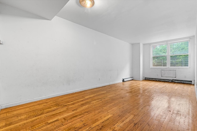 718 Garden St, Bronx, NY 10457 - spare room featuring baseboard heating, hardwood / wood-style floors, and a baseboard radiator