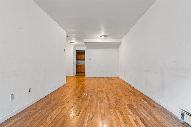 718 Garden St, Bronx, NY 10457 - unfurnished room featuring baseboard heating and light wood-style flooring