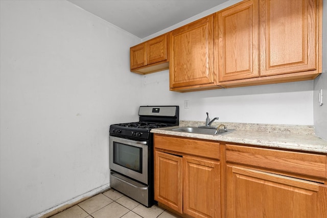 718 Garden St, Bronx, NY 10457 - kitchen featuring gas range, light tile patterned flooring, light countertops, and brown cabinetry