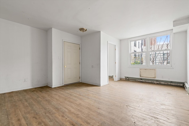 718 Garden St, Bronx, NY 10457 - spare room featuring wood finished floors and a baseboard radiator