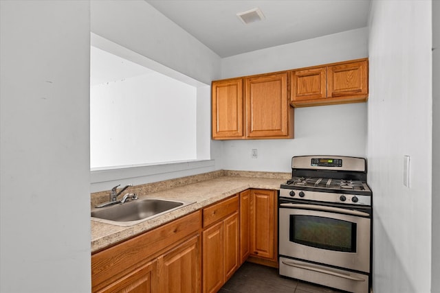 718 Garden St, Bronx, NY 10457 - kitchen featuring stainless steel gas range oven, light countertops, and brown cabinets