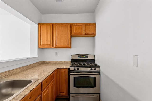 718 Garden St, Bronx, NY 10457 - kitchen featuring gas range, light countertops, and brown cabinetry