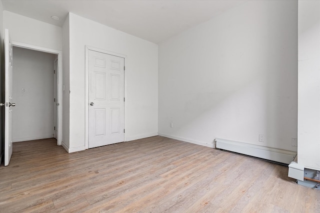 718 Garden St, Bronx, NY 10457 - unfurnished bedroom featuring a baseboard heating unit and light wood finished floors