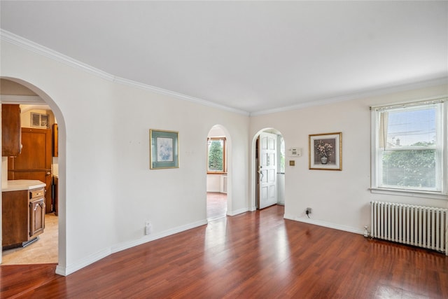 662 Benris Ave, Franklin Square, NY 11010 - empty room featuring radiator heating unit, arched walkways, wood finished floors, and ornamental molding
