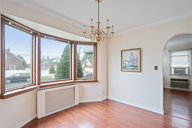 662 Benris Ave, Franklin Square, NY 11010 - unfurnished room featuring radiator, a wall mounted air conditioner, arched walkways, plenty of natural light, and crown molding