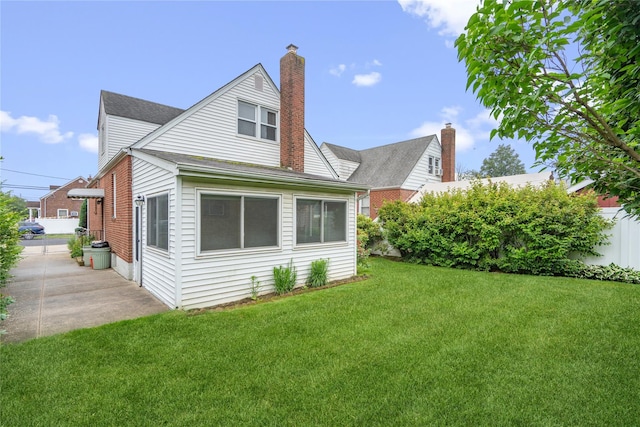 662 Benris Ave, Franklin Square, NY 11010 - back of house with a yard, a shingled roof, and a chimney