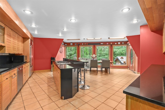 295 N Salem Rd, Waccabuc, NY 10597 - kitchen featuring appliances with stainless steel finishes, dark countertops, recessed lighting, light tile patterned floors, and a breakfast bar