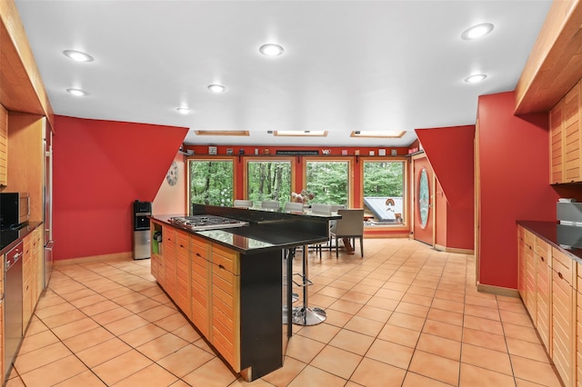 295 N Salem Rd, Waccabuc, NY 10597 - kitchen with stainless steel gas cooktop, a breakfast bar area, dark countertops, recessed lighting, and light tile patterned floors