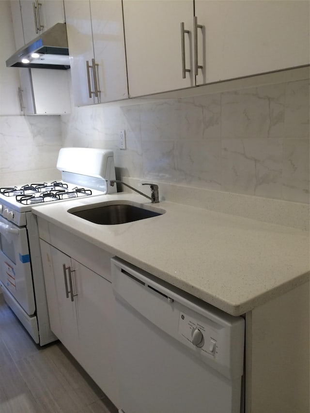 1004 Rhinelander Ave, Bronx, NY 10462 - kitchen with white appliances, under cabinet range hood, white cabinets, and light stone countertops