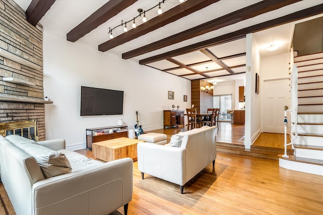 88-37 74th Ave, Glendale, NY 11385 - living room with a chandelier, stairway, light wood-style flooring, beamed ceiling, and a large fireplace