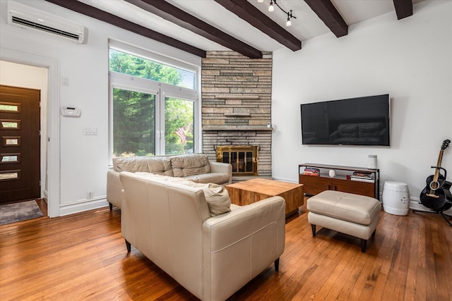 88-37 74th Ave, Glendale, NY 11385 - living room featuring an AC wall unit, wood-type flooring, beam ceiling, and a fireplace