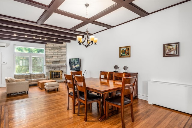 88-37 74th Ave, Glendale, NY 11385 - dining area with a chandelier, hardwood / wood-style flooring, an AC wall unit, a stone fireplace, and coffered ceiling
