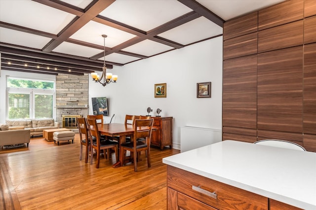 88-37 74th Ave, Glendale, NY 11385 - dining area with coffered ceiling, light wood finished floors, a chandelier, a fireplace, and beam ceiling