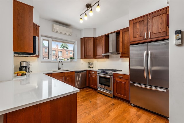 88-37 74th Ave, Glendale, NY 11385 - kitchen with stainless steel appliances, wall chimney exhaust hood, a wall mounted air conditioner, light countertops, and light wood-type flooring