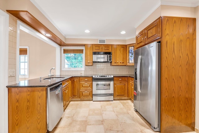 51 Highfield Ave, Port Washington, NY 11050 - kitchen with appliances with stainless steel finishes, brown cabinetry, a peninsula, decorative backsplash, and ornamental molding