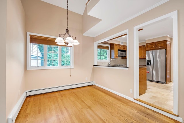 51 Highfield Ave, Port Washington, NY 11050 - unfurnished dining area with baseboard heating, a chandelier, light wood-style flooring, and ornamental molding