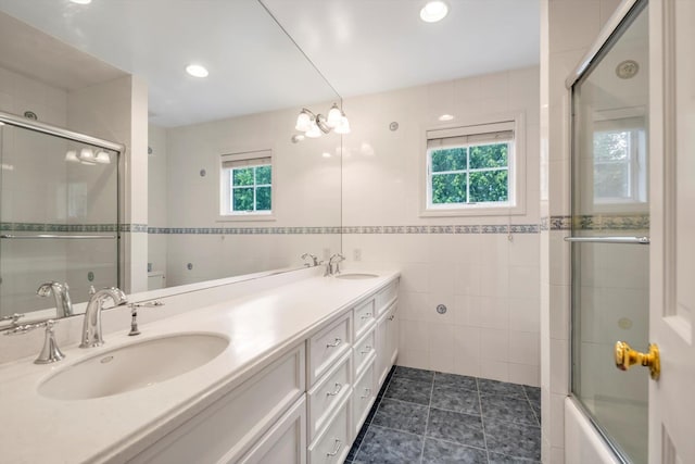 51 Highfield Ave, Port Washington, NY 11050 - bathroom featuring tile walls, double vanity, combined bath / shower with glass door, tile patterned flooring, and recessed lighting
