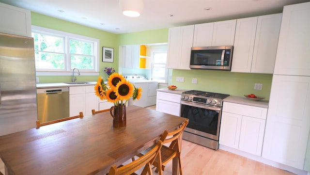 412 Atlantic Ave, Greenport, NY 11944 - kitchen featuring stainless steel appliances, independent washer and dryer, white cabinetry, and light countertops