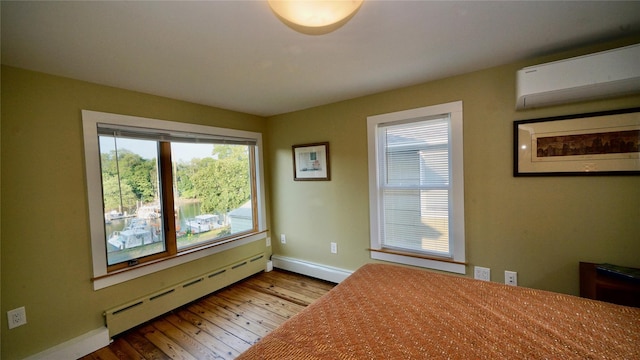 412 Atlantic Ave, Greenport, NY 11944 - unfurnished bedroom featuring a baseboard heating unit, a wall unit AC, and wood-type flooring
