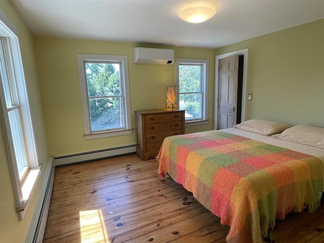 412 Atlantic Ave, Greenport, NY 11944 - bedroom with a baseboard heating unit, a wall mounted AC, and light wood-style floors
