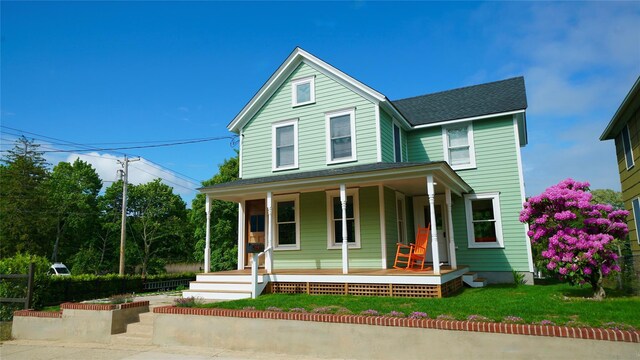 412 Atlantic Ave, Greenport, NY 11944 - view of front of property featuring a porch, roof with shingles, and a front lawn