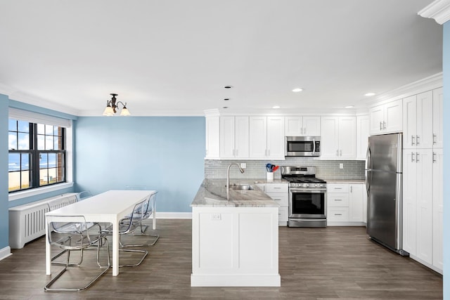 26 W Broadway Unit 405, Long Beach, NY 11561 - kitchen with stainless steel appliances, radiator heating unit, white cabinetry, decorative backsplash, and recessed lighting