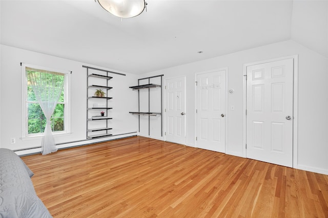 18 Jenkins Ct, Ossining, NY 10562 - unfurnished bedroom featuring light wood-type flooring, a baseboard radiator, and lofted ceiling