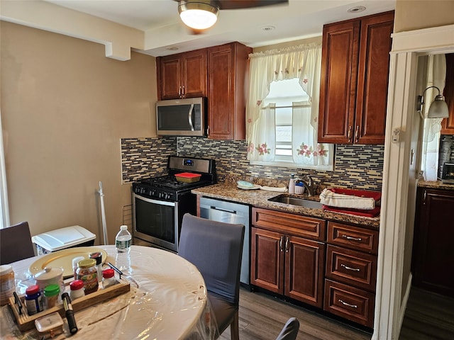 1430 Gipson St, Far Rockaway, NY 11691 - kitchen featuring appliances with stainless steel finishes, backsplash, dark wood-style flooring, and dark stone counters