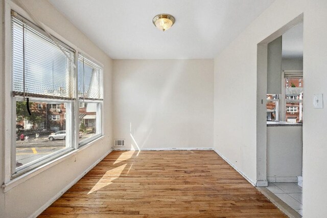 214-04 18th Ave, Bayside, NY 11360 - empty room with light wood-style flooring and baseboards