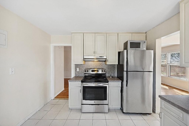 214-04 18th Ave, Bayside, NY 11360 - kitchen featuring stainless steel appliances, under cabinet range hood, decorative backsplash, and light tile patterned flooring