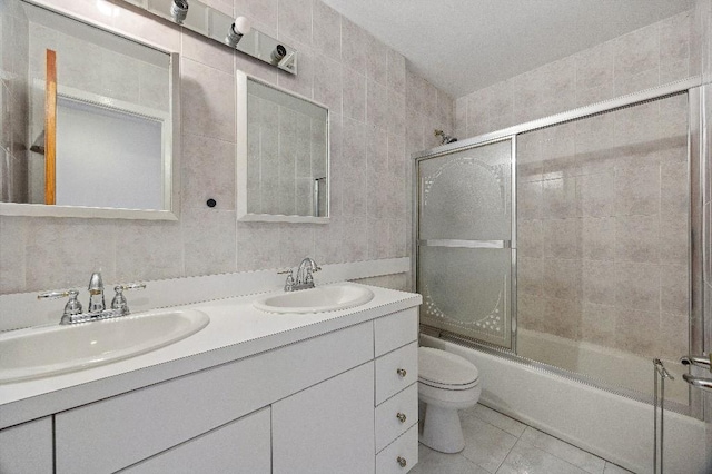 214-04 18th Ave, Bayside, NY 11360 - bathroom featuring double vanity, combined bath / shower with glass door, tile patterned floors, and tile walls