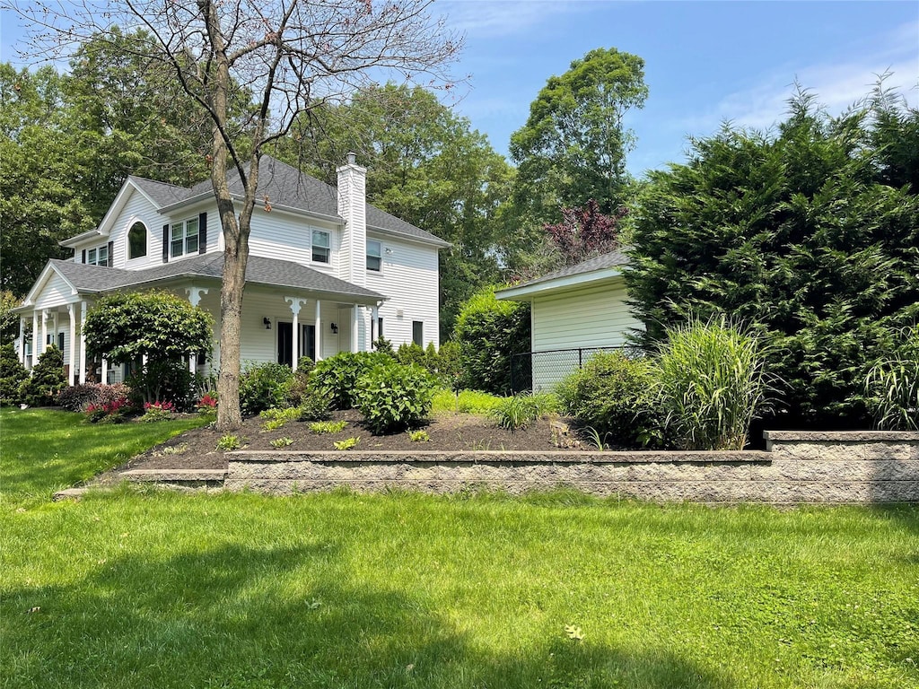 2 William St, East Setauket, NY 11733 - view of front of property featuring a chimney, a shingled roof, and a front yard