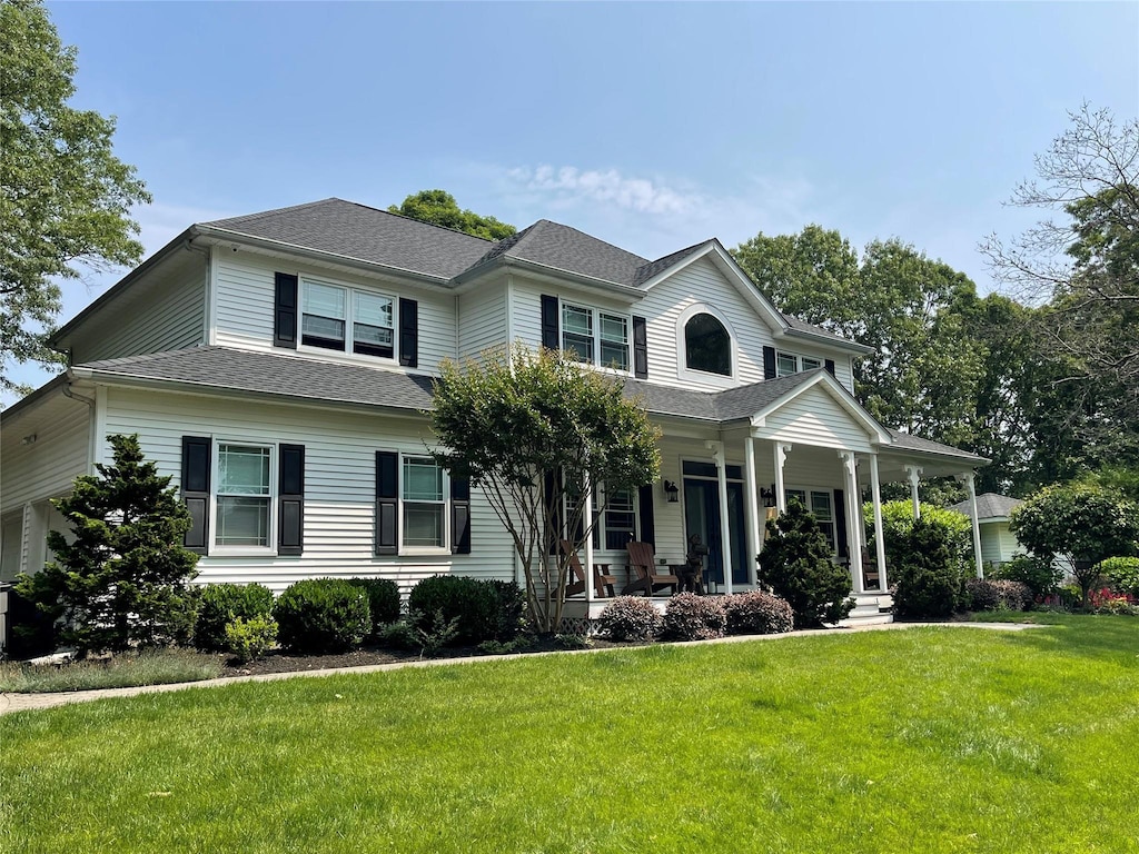 2 William St, East Setauket, NY 11733 - view of front facade with a front yard, covered porch, and roof with shingles