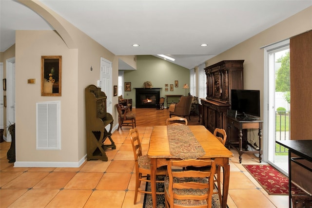 15 Howard Ct, Plainview, NY 11803 - dining room with plenty of natural light, a warm lit fireplace, light tile patterned flooring, lofted ceiling, and recessed lighting