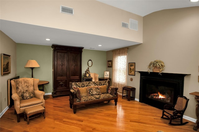 15 Howard Ct, Plainview, NY 11803 - living area featuring light wood finished floors, a lit fireplace, recessed lighting, and vaulted ceiling