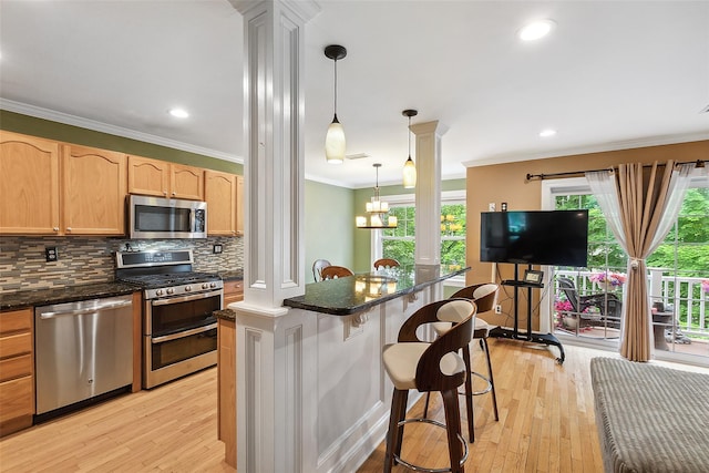 97 Hillcrest Ln, Peekskill, NY 10566 - kitchen featuring appliances with stainless steel finishes, ornate columns, crown molding, light wood-style floors, and backsplash