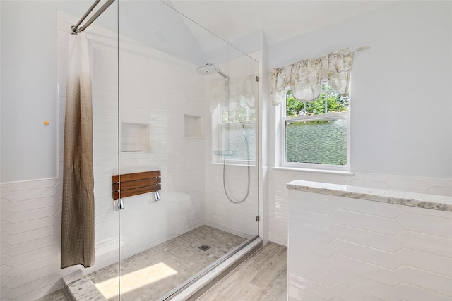 97 Hillcrest Ln, Peekskill, NY 10566 - bathroom featuring tiled shower, a wainscoted wall, wood finished floors, and tile walls