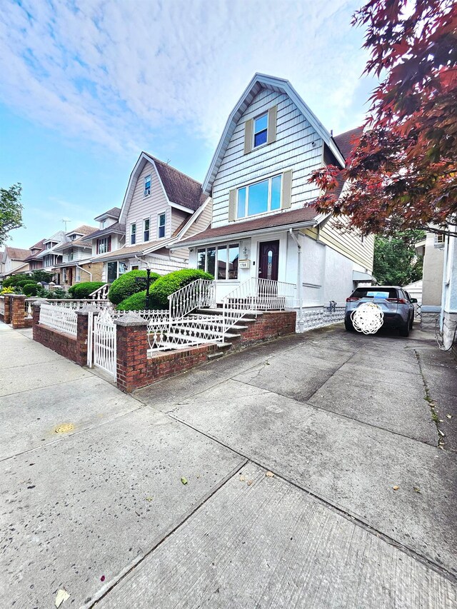 1768 W 5th St, Brooklyn, NY 11223 - dutch colonial with a fenced front yard, a gate, driveway, and a gambrel roof