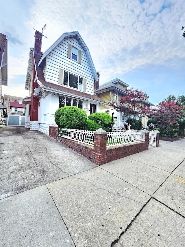 1768 W 5th St, Brooklyn, NY 11223 - view of front of home featuring a fenced front yard, a chimney, a gambrel roof, and a gate