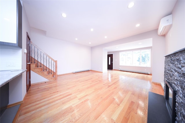 1768 W 5th St, Brooklyn, NY 11223 - unfurnished living room featuring a fireplace, a wall mounted air conditioner, stairs, light wood-style floors, and a baseboard radiator