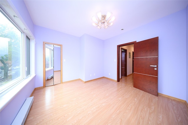1768 W 5th St, Brooklyn, NY 11223 - empty room featuring a chandelier, a baseboard radiator, and light wood finished floors