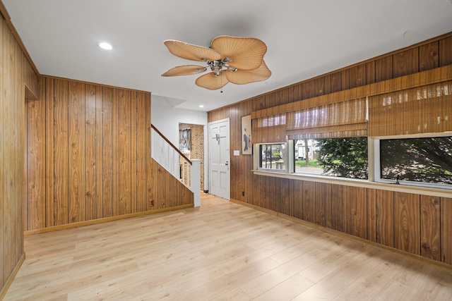 302 Waukena Ave, Oceanside, NY 11572 - unfurnished room featuring stairway, wood walls, wood finished floors, and ceiling fan