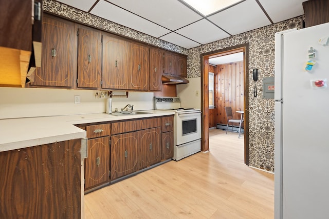 302 Waukena Ave, Oceanside, NY 11572 - kitchen featuring white appliances, under cabinet range hood, a baseboard heating unit, light wood-type flooring, and light countertops
