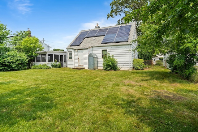 302 Waukena Ave, Oceanside, NY 11572 - rear view of property featuring a sunroom, a shingled roof, solar panels, and a chimney