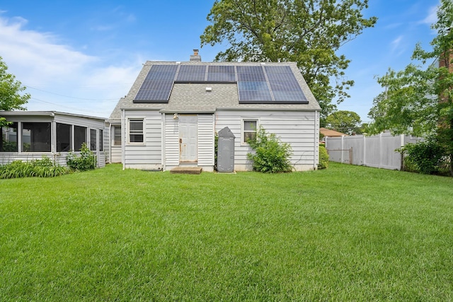 302 Waukena Ave, Oceanside, NY 11572 - rear view of house featuring a shingled roof, a chimney, a sunroom, and roof mounted solar panels