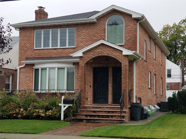 45-44 E 189th St, Flushing, NY 11368 - view of front of house featuring a chimney, brick siding, and a front yard