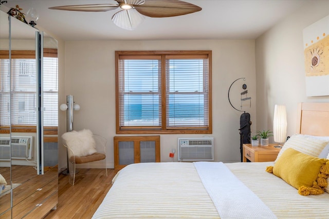 522 Shore Rd Unit 4Kk, Long Beach, NY 11561 - bedroom with a wall unit AC, multiple windows, light wood-style flooring, and a ceiling fan