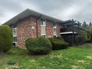 1201 Old Country Rd, Elmsford, NY 10523 - view of side of property with brick siding and a yard